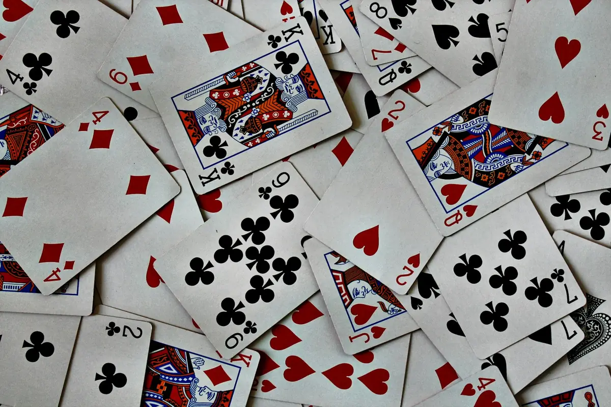 Kartu poker tersebar di atas meja bersama tumpukan keping